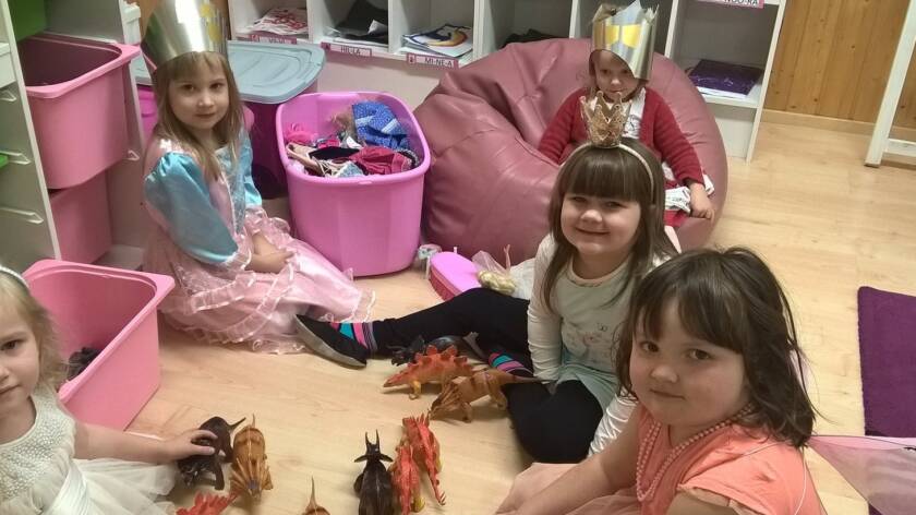 Lapsia leikkimässä pukeutuneina prinsessoiksi.