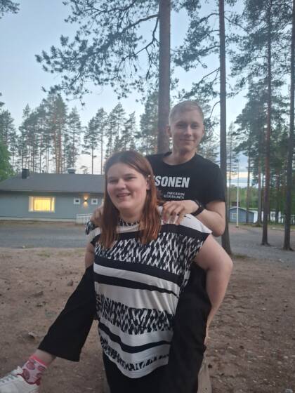 Nuori kantaa toista reppuselässä.