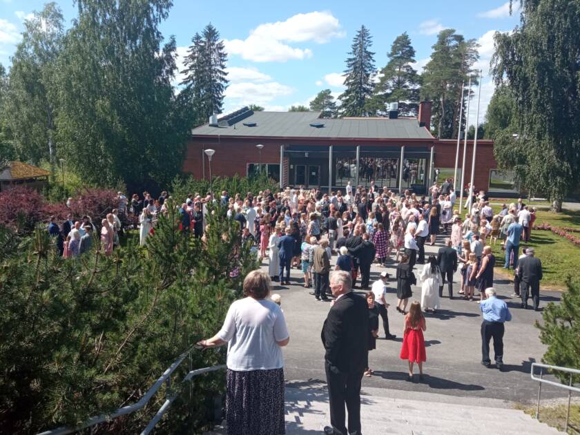 Väenpaljous Parkanon seurakuntatalon edessä kesäisenä päivänä.