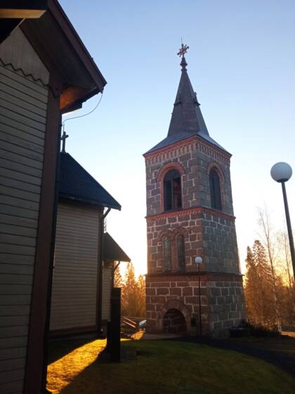 Parkanon kirkon kellotapuli auringonlaskun edessä.