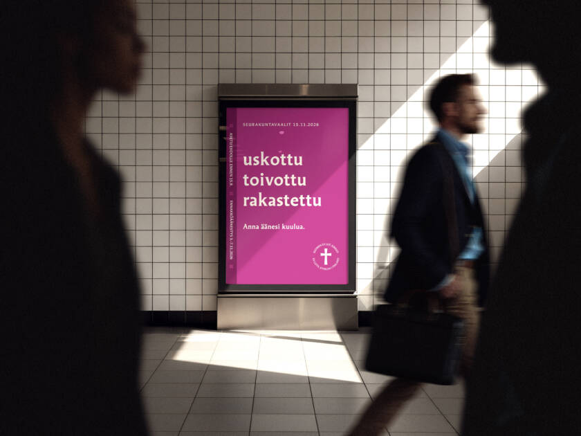 Edustalla ihmisiä kävelemässä, taustalla seurakuntavaalimainos.