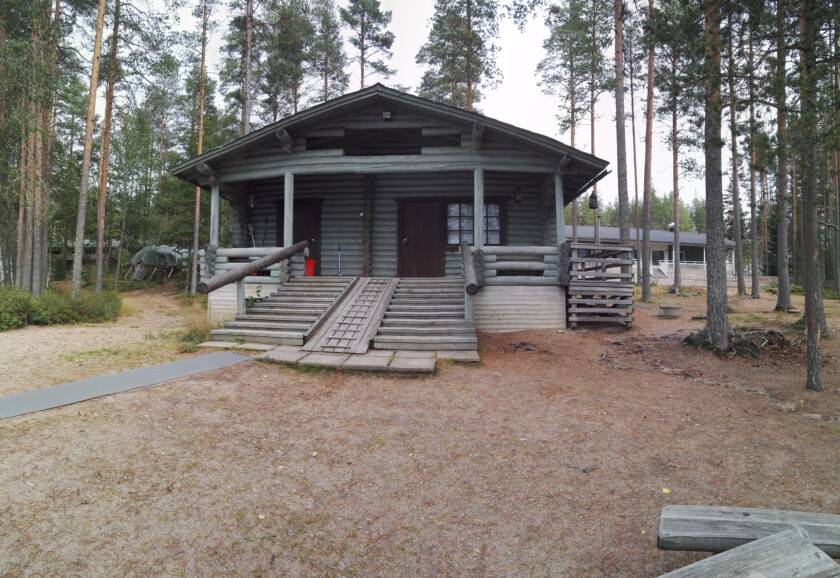 Poikkeusharjun leirikeskuksen sauna edestäpäin, taustalla päärakennus.
