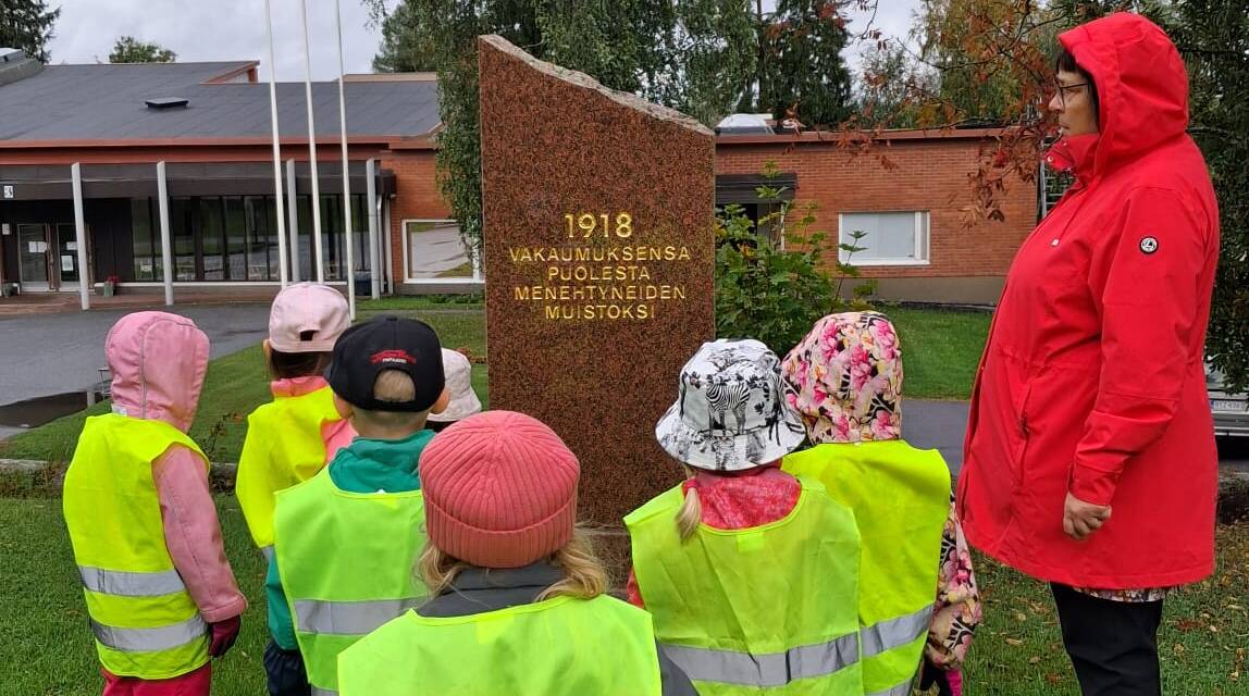 Ohjaaja Merja esittelemässä lapsille Vakaumuksensa puolesta menehtyneiden muistomerkkiä.